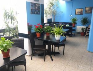 a restaurant with tables and chairs and potted plants at Aladin Praha in Prague