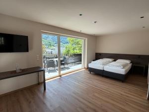 a bedroom with two beds and a large window at Hotel Harpf in Bressanone +17 photos