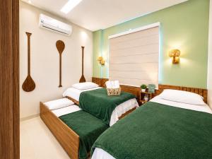 two beds in a room with green and white at Apartamento Moderno e Aconchegante 2 Quartos Ar Condicionado in Alter do Chao