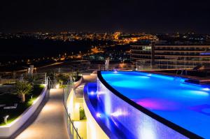 a swimming pool on top of a building at night at Infinity View Apartments by NRAS in Arenales del Sol