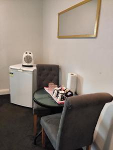 a room with a table and a chair and a mirror at North Beach Lodge in Christchurch