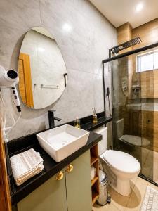 a bathroom with a sink and a toilet and a mirror at Apartamento Moderno e Aconchegante 2 Quartos Ar Condicionado in Alter do Chao +9 photos