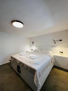 a bedroom with a bed with a white bedspread at Aloni Petit House in Nerotriviá