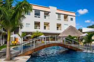 a bridge over a pool in front of a hotel at Apartamento Moderno e Aconchegante 2 Quartos Ar Condicionado in Alter do Chao
