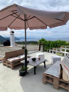 a patio with an umbrella and a table and chairs at Το σπίτι της Ελένης in Vlakhiá