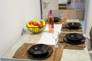a table with plates and glasses and a bowl of fruit at Stellar Island Home-Kos in Kos