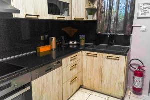a kitchen with wooden cabinets and a black counter top at Stellar Island Home-Kos in Kos