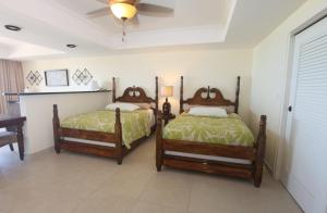 a bedroom with two beds and a ceiling at The Crown House Hotel in Philipsburg