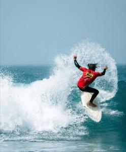 a person riding a wave on a surfboard in the ocean at Arrifana Surf Camp in Aljezur