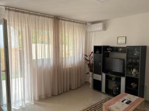 a living room with a television and a large window at Tara Apartment in Herceg-Novi