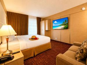 a hotel room with a bed and a flat screen tv at Ocean Beach Club in Fort Lauderdale