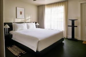 a bedroom with a large white bed and a window at Perroquet Hotel in Fort Lauderdale +62 photos