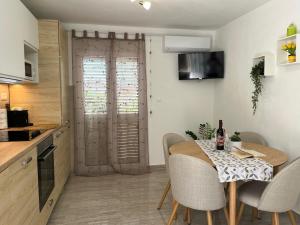 a kitchen and dining room with a table and chairs at Apartments Bepo in Komiža