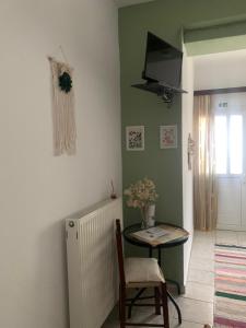 a room with a table and a television on the wall at Το σπίτι της Ελένης in Vlakhiá