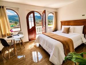 a hotel room with a bed and a table and windows at Mansión Altamirano - Hotel in Talavera +28 photos