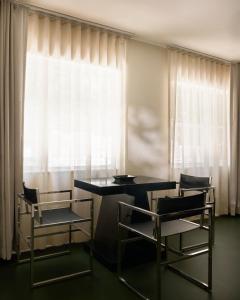 a dining room with two chairs and a table and a window at Perroquet Hotel in Fort Lauderdale