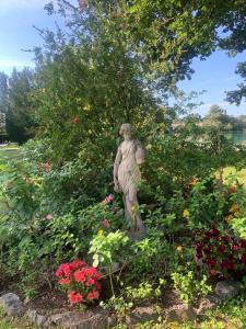 a statue of a woman in a garden with flowers at Chambre dans charmant Cottage dans résidence agréable in Grasse