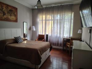a bedroom with a bed and a table and a window at Rio amazonas 7 in Mexico City