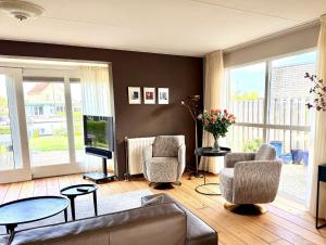a living room with a couch and two chairs and a television at Villa Water en Meer in Terherne