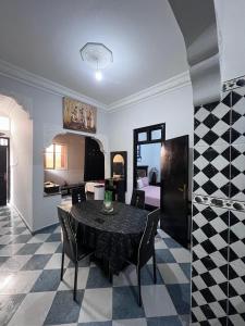 a dining room with a table and a bedroom at Appartement Maroc Safi in Safi