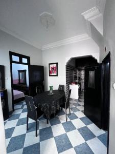 a dining room with a black table and chairs at Appartement Maroc Safi in Safi
