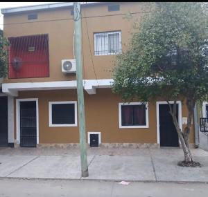a building with a tree in front of it at Fortunata Urban in San Miguel de Tucumán