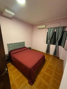a bedroom with a red bed in a room at Fortunata Urban in San Miguel de Tucumán