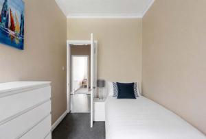 a bedroom with a white bed with a blue pillow at Lady Mary Sea View in Rothesay