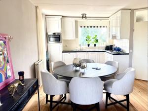 a kitchen with a dining room table and chairs at Villa Water en Meer in Terherne