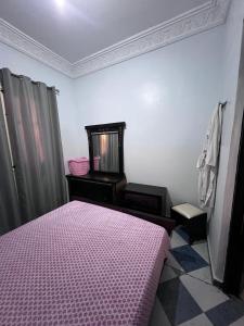 a bedroom with a pink bed and a mirror at Appartement Maroc Safi in Safi