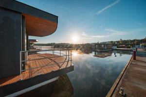 a dock with the sun setting over a body of water at Floatinghouse Heaven on Earth in Klitten