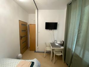 a bedroom with a desk and a bed and a television at Diskrepant Budget Room in Warsaw