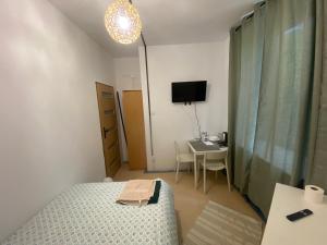 a bedroom with a bed and a desk and a television at Diskrepant Budget Room in Warsaw +9 photos