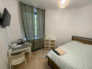 a bedroom with a bed and a desk and a television at Diskrepant Budget Room in Warsaw