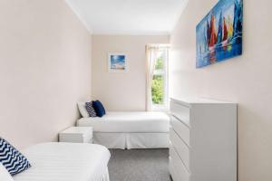 a white living room with a couch and a chair at Lady Mary Sea View in Rothesay