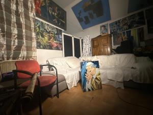 a living room with a white couch and a painting of a pope at Villatopol Art Hostel in Rząska