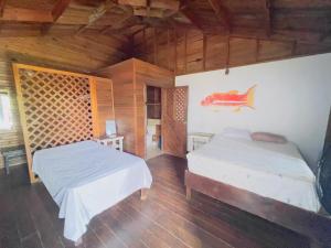 two beds in a room with wooden walls and wooden floors at LOTO'S House in West End