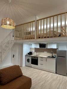 a living room with a kitchen and a staircase at Le Cocon du Royat Palace in Royat