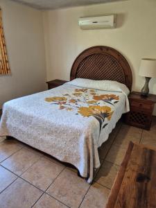 a bedroom with a bed with a blanket on it at Hotel Lorimar in La Paz