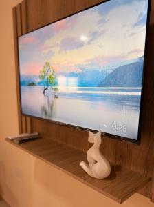 a television screen with a cat sitting on a shelf at Apart Zona Paula in San Juan