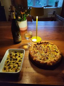 a pizza sitting on a table next to a bottle of wine at CAMPING Pleine Nature in Boule - dÊ¼Amont