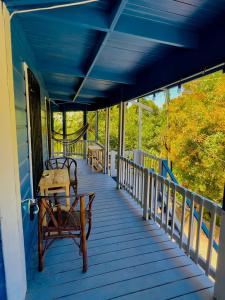 a blue porch with two benches and a table at LOTO'S House in West End