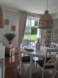 a dining room with a white table and chairs at Maison ensoleillée plage a pied in Houlgate