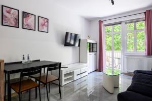 a living room with a table and a tv at Świętego Mikołaja 14 Centrum in Głogów