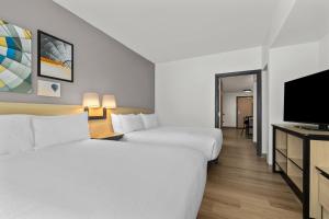 a hotel room with two beds and a flat screen tv at City Express by Marriott St. Augustine in St. Augustine