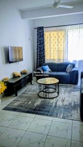 a living room with a blue couch and a table at Ryma Airbnbs in Mombasa