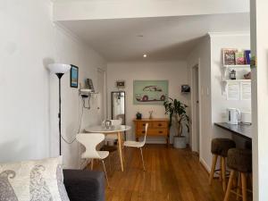 a living room with a table and chairs and a kitchen at Beachfront Apartment in Melbourne