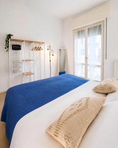 a white bedroom with a blue and white bed at Al Carlino Verona in Verona