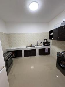a small kitchen with a sink and a stove at La Kribienne in Cotonou