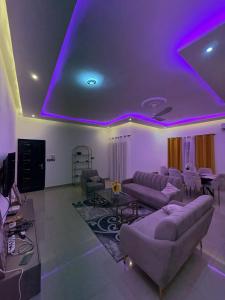 a living room with purple lights on the ceiling at La Kribienne in Cotonou +1 photo
